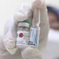 Tenaga kesehatan menunjukkan vaksin meningitis yang sesaat sebelum disuntikkan ke para calon jamaah Haji di Puskesmas Pasar Minggu, Jakarta, Rabu (17/4/2024). (Liputan6.com/Herman Zakharia)
