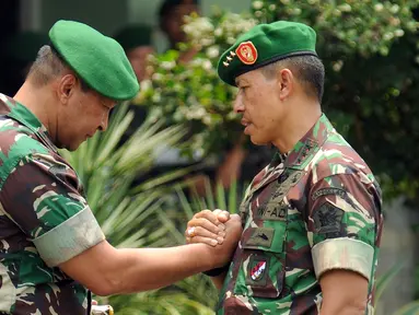 Letjen TNI Agus Sutomo (kanan) bersalaman dengan Mayjen Teddy Lhaksmana WK saat Apel Bersama Satuan Jajaran Kodam Jaya di Makodam Jaya, Jakarta, Kamis (17/9/2015). Apel diiringi serah terima jabatan Pangdam Jaya. (Liputan6.com/Helmi Fithriansyah)