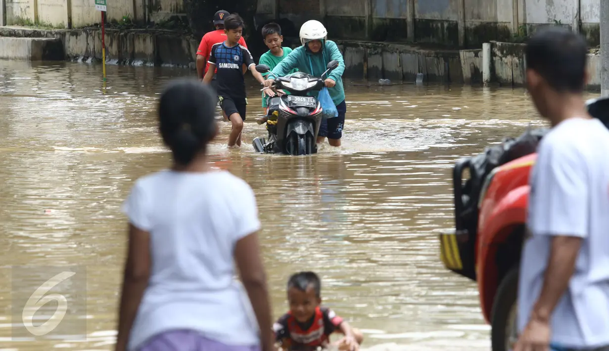 Warga mendorong motornya yang mogok menerobos banjir di kawasan Bukit Duri, Jakarta Selatan, Kamis (16/2). Banjir dengan ketinggian 10 - 80 cm di wilayah Bukit Duri disebabkan meluapnya Bendungan Katulampa, Bogor. (Liputan6.com/Helmi Afandi)