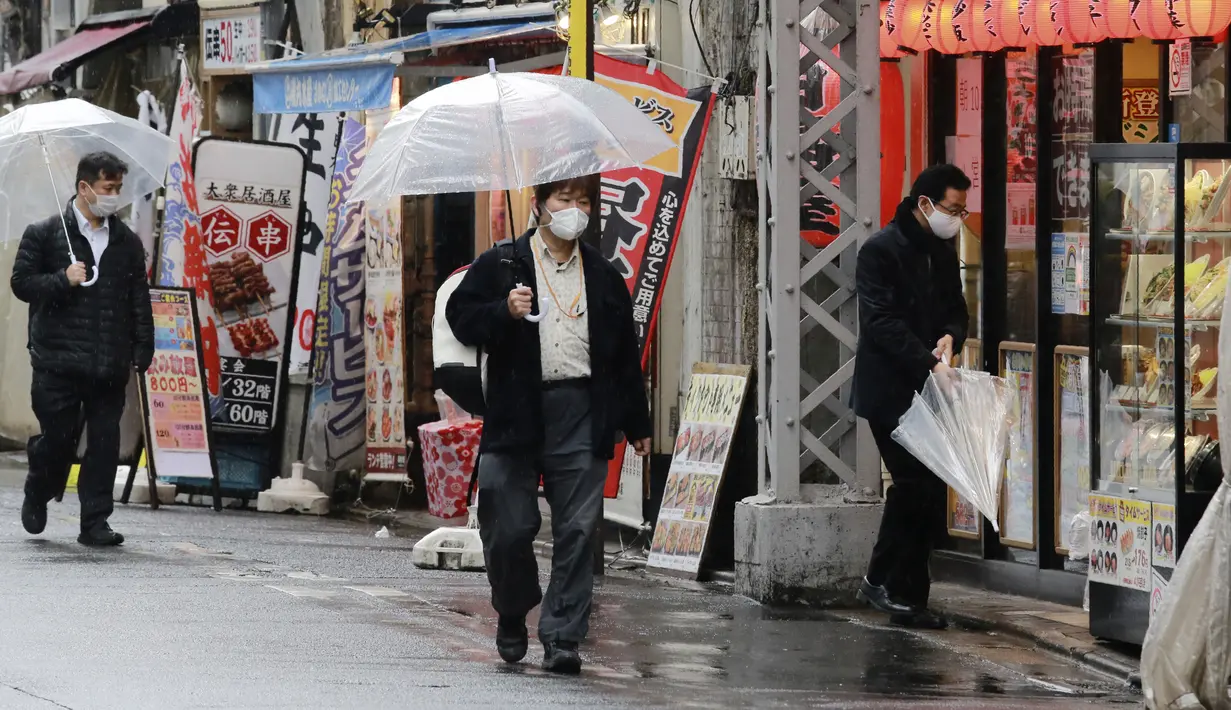 Warga memakai masker untuk melindungi dari penyebaran virus corona berjalan di jalan yang dipenuhi bar dan restoran di Tokyo (8/3/2021). Pemerintah Jepang memperpanjang keadaan darurat di wilayah Tokyo hingga 21 Maret karena sistem medis masih disaring oleh pasien COVID-19. (AP Photo/Koji Sasahara)