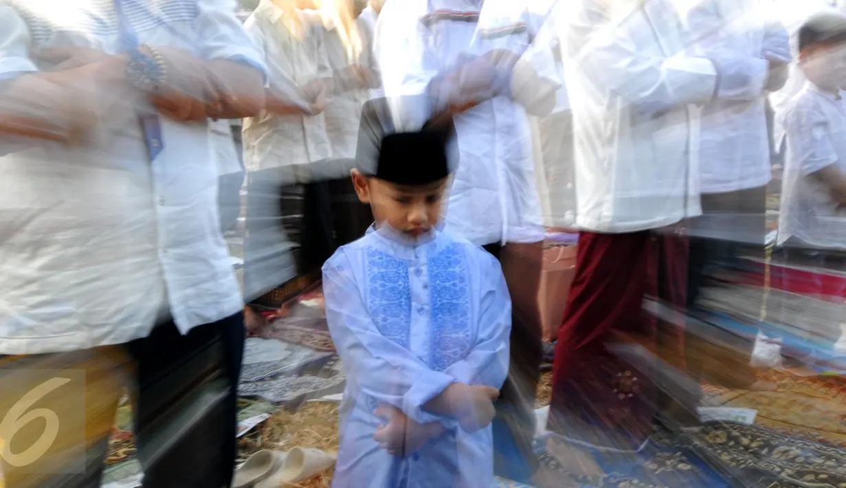 Ribuan umat muslim menunaikan ibadah salat Idul Fitri 1 Syawal 1436 H di Masjid Agung Al Azhar Jakarta, Jumat (17/7/2015). Tampak, salah satu anak terlihat khusyuk saat melaksanakan salat Id di halaman Masjid Agung Al Azhar. (Liputan6.com/Yoppy Renato)