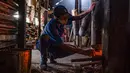 Pekerja memeriksa kayu bakar sebelum memanggang biji kopi di Pabrik Kopi Antong, Taiping, Perak, Malaysia, 29 September 2020. Pabrik Kopi Antong menggunakan mesin antik dan metode pemanggangan tradisional untuk menghasilkan bubuk sarat kafein yang terkenal selama 87 tahun. (Mohd RASFAN/AFP)