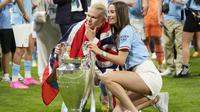 Pemain Manchester City, Erling Haaland, berpose bersama kekasihnya Isabel Haugseng Johansen saat perayaan gelar juara Liga CHampions di Ataturk Olympic Stadium, Istanbul, Minggu (11/6/2023). Erling Haaland tampil luar biasa dan mampu meraih treble winner di musim perdananya bersama City. (AP Photo/Francisco Seco)