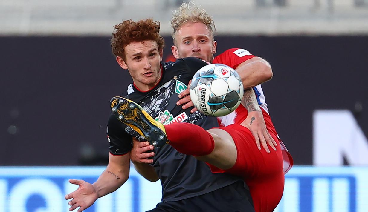 Penyerang werder Bremen, Joshua Sargent, berebut bola dengan pemain Heidenheim 1846 pada laga lay-off leg kedua di Voith-Arena, Selasa (7/7/2020) dini hari WIB. Bremen bermain imbang 2-2 atas Heidenheim. (AFP/Kai Pfaffenbach/pool)
