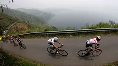 Para pebalap sepeda melewati tanjakan di samping Danau Singkarak dalam Etape 4 Tour de Singkarak 2015 antara Sawahlunto-Solok Selatan, Selasa (6/10/2015). (Bola.com/Arief Bagus)