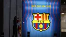 Seorang pekerja menurunkan bendera institusi dan klub sebelum kantor Barcelona tutup pada hari itu di stadion Camp Nou di Barcelona, Spanyol, Kamis (5/8/2021). Barcelona pada Kamis 5 Agustus 2021 bahwa Lionel Messi tidak akan bertahan dengan klub. (AP Photo/Joan Monfort)