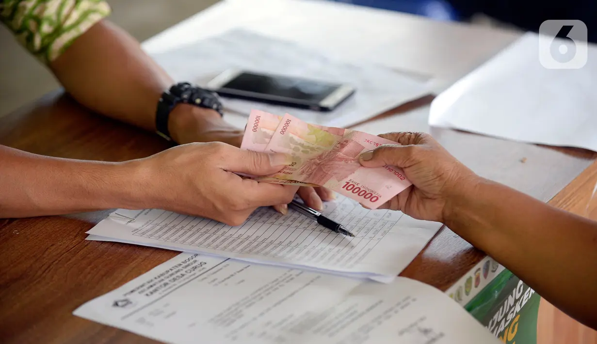 Petugas sedang menyerahkan Bantuan Langsung Tunai Dana Desa (BLT-DD) kepada warga Desa Curug di Kantor Desa Curug, Gunung Sindur, Kabupaten Bogor, Jawa Barat, Kamis (17/09/2020). (merdeka.com/Dwi Narwoko)