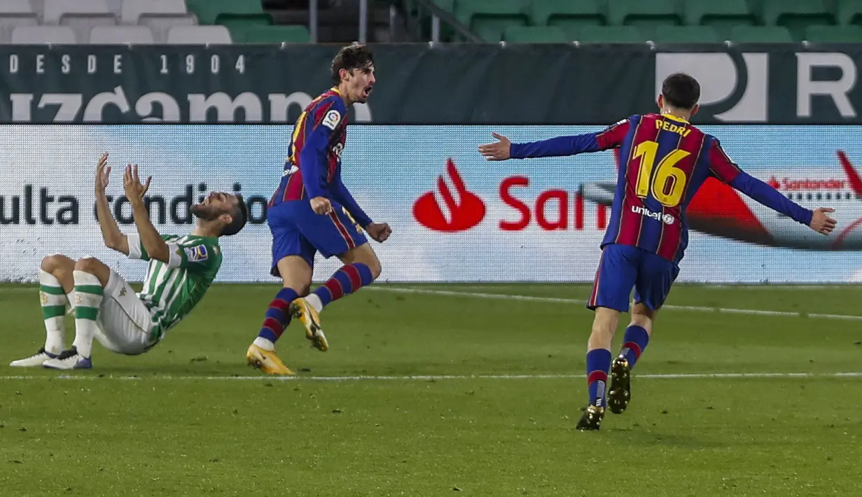 Penyerang Barcelona, Francisco Trincao (tengah) berselebrasi usai mencetak gol ke gawang Real Betis pada lanjutan La Liga Spanyol di stadion Benito Villamarin di Seville, Spanyol, Senin (8/2/2021).  Kemenangan ini membuat Barcelona berada di posisi dua pada klasemen. (AP Photo/Miguel Morenatti)