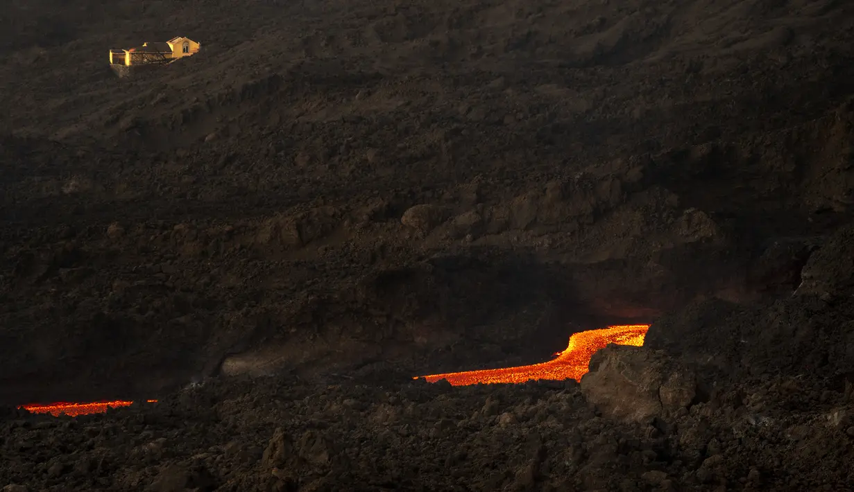 Lava gunung berapi Cumbre Vieja yang meletus mengalir di Pulau Canary La Palma, Spanyol, 29 Oktober 2021. Gunung berapi Cumbre Vieja yang terus meletus mengeluarkan sejumlah besar magma, gas dan abu. (AP Photo/Emilio Morenatti)