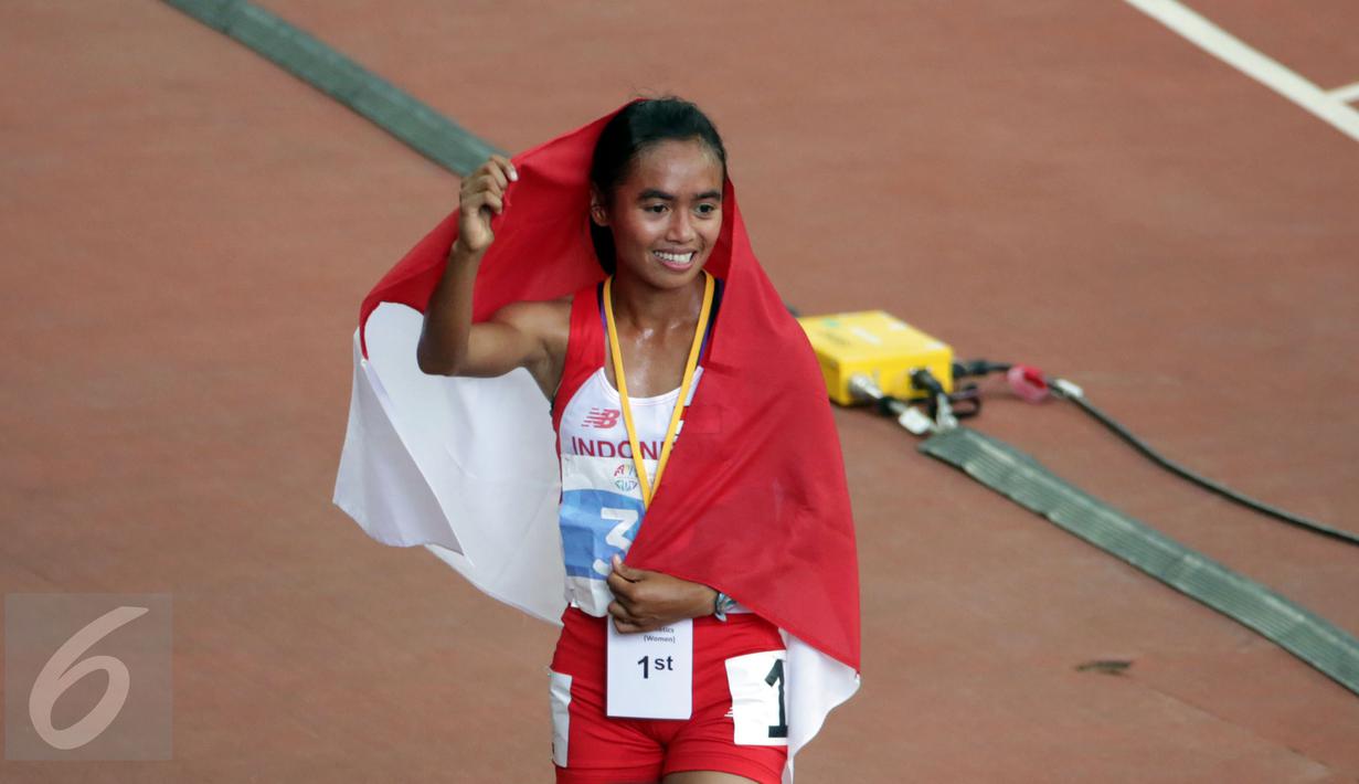 Atlet putri Indonesia, Triyaningsih berpose saat melakukan perayaan kemenangannya di nomor 10.000 M di National Stadium Singapura, Kamis (11/6/2015). Triyaningsih mencatatkan waktu 33 menit 44,53 detik. (Liputan6.com/Helmi Fithriansyah)