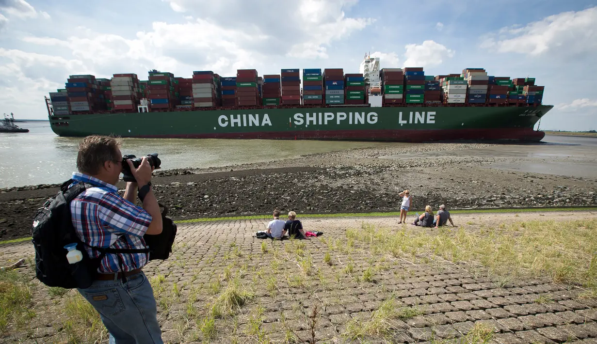 Seorang warga mengabadikan gambar kapal kontainer CSCL Jupiter Hong Kong yang terdampar di muara Westerschelde di dekat kota Bath di Belanda setelah insiden grounding (14/8).  (AFP PHOTO/Belga/Kristof Van Accom/Belgium Out)