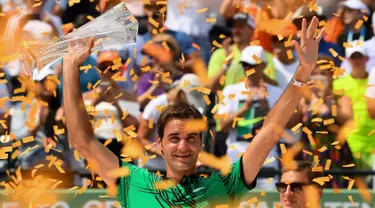 Petenis Swiss, Roger Federer mengangkat tropi usai memenangkan pertandingan pada final Miami Terbuka di Crandon Park, Florida (2/4). Federer menundukkan rival lamanya, Rafael Nadal dua set langsung 6-3, 6-4. (Rob Foldy / Getty Images / AFP)