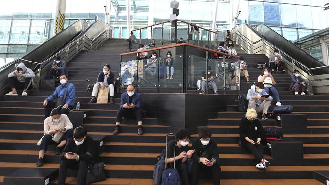 Orang-orang yang memakai masker wajah untuk membantu melindungi dari penyebaran virus corona menunggu kereta mereka menjelang liburan Chuseok atau Hari Thanksgiving versi Korea di Stasiun Kereta Seoul di Seoul, Korea Selatan, Selasa (29/9/2020). (AP Photo / Ahn Young-joon)