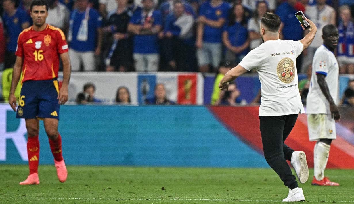 Semifinal Euro 2024 antara Spanyol dan Prancis dihentikan sementara ketika seorang penonton berlari ke lapangan selama pertandingan. (JAVIER SORIANO / AFP)