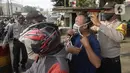 Anggota polisi dari Polsek Parung membantu memasangkan masker kepada pengendara sepeda motor di depan Polsek Parung, Kabupaten Bogor, Jawa Barat, Rabu (2/9/2020). Pembagian masker gratis ini untuk mengajak masyarakat hidup sehat dan mencegah penular COVID-19. (merdeka.com/Dwi Narwoko)