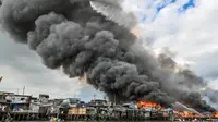 Helikopter Angkatan Udara Filipina menjatuhkan air di atas pemukiman kumuh yang terbakar di Tondo, Manila, Filipina. (AFP)