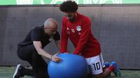 Pemain timnas Mesir Mohamed Salah dibantu tim kesehatan melatih bahunya yang cedera saat pelatihan di stadion Akhmat Arena di Grozny (12/6). Pemain Liverpool ini cedera saat tampil di Final Liga Champions melawan Real Madrid. (AFP Photo/Karim Jaafar)