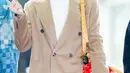 Salah satu member boyband Riize yang juga merupakan house ambassador Louis Vuitton, Anton tampil memesona dengan outfit musim dinginnya di bandara. Ia memadukan long coat warna khaki dengan turtleneck sweater warna putih dan tas LV Speedy P9 warna merah.  [X/@kpopers_family]