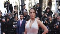 Pasangan Cristiano Ronaldo, Georgina Rodriguez berpose untuk fotografer setibanya di pemutaran perdana film 'Elvis' di festival film internasional ke-75, Cannes, Prancis selatan, Rabu (25/5/2022). Untuk melengkapi penampilan glamornya, Georgina Rodriguez memilih eyeshadow warna bronze dan lipstik merah muda cerah. (Vianney Le Caer/Invision/AP)