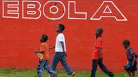 Sejumlah anak berjalan melewati dinding yang bertuliskan 'Ebola' di Monrovia, Liberia, 31 Agustus 2014. Liberia melarang para awak kapal untuk berlabuh di negara-negara yang rentan epidemi Ebola. (AFP PHOTO/DOMINIQUE FAGET)