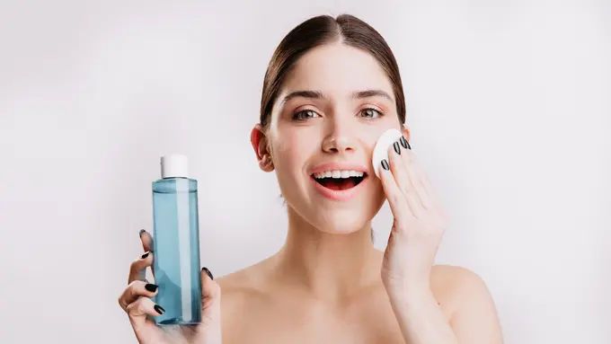Seorang perempuan sedang membersihkan wajahnya menggunakan micellar water (Foto Dok: Freepik/lookstudio)