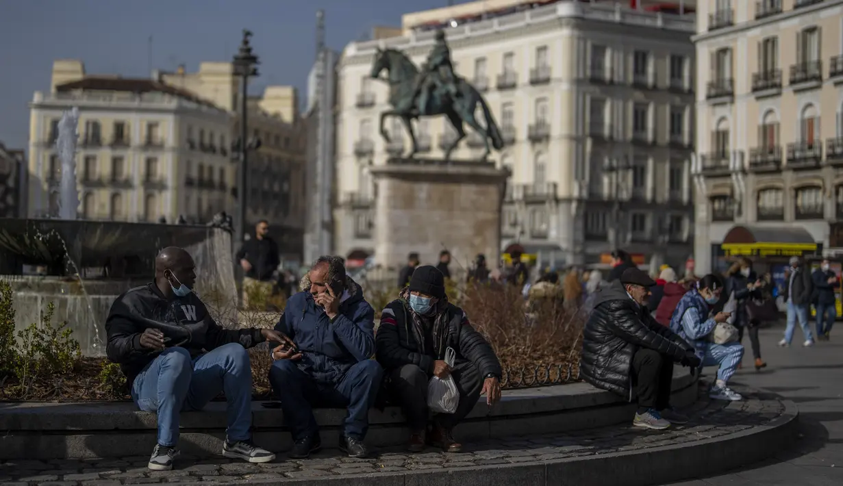 Orang-orang, beberapa dari mereka tanpa masker, berkumpul di Sol square di pusat kota Madrid, Kamis (10//2/2022). Warga Spanyol untuk pertama kalinya dalam hampir dua bulan diperbolehkan tidak menggunakan masker di luar ruangan setelah peraturan terkait hal itu dicabut. (AP Photo/Manu Fernandez)