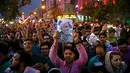 Seorang pendukung Presiden Iran Hassan Rouhani membawa poster saat merayakan kemenangannya dalam pemilihan presiden Iran di Teheran, Iran (20/5). (AP Photo/Ebrahim Noroozi)