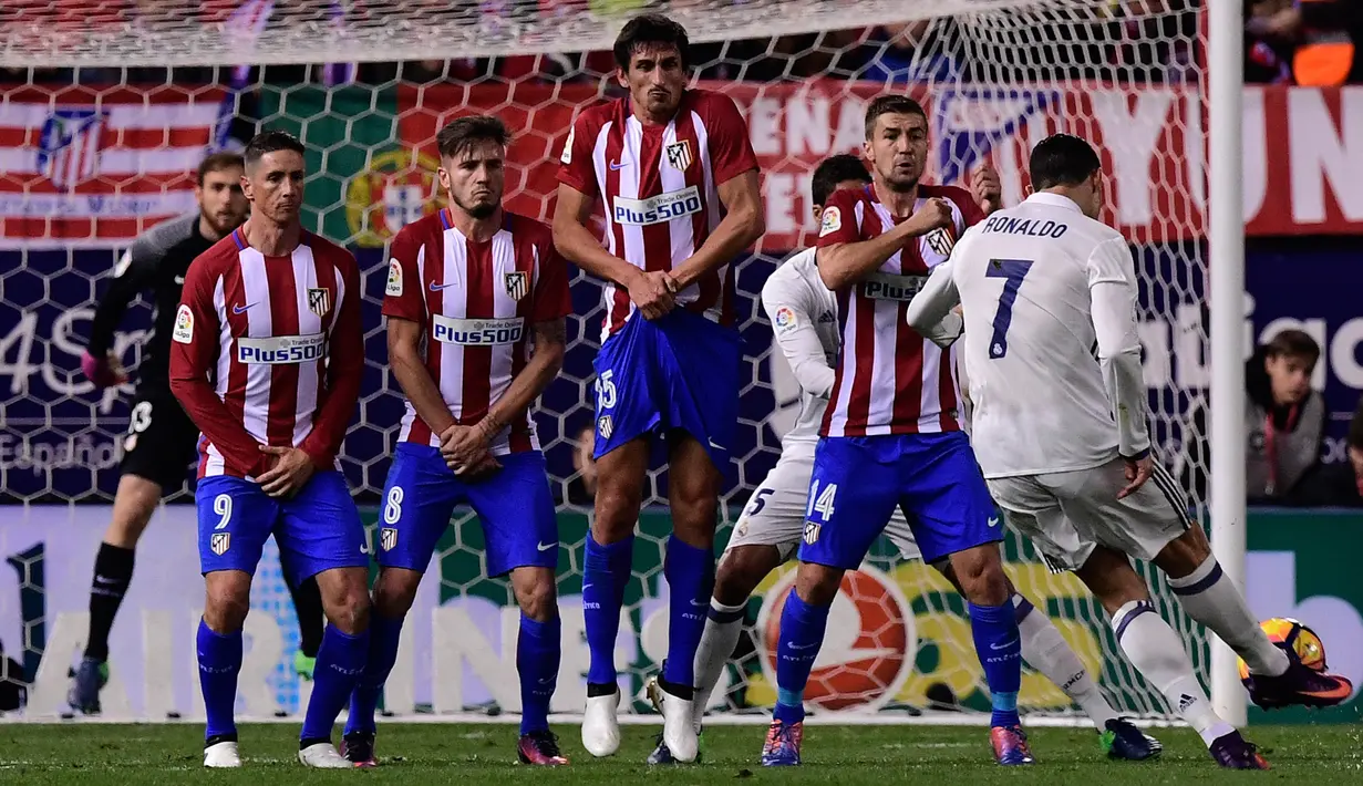 Cristiano Ronaldo melakukan tendangan bebas saat berhadapan Atletico Madrid pada Liga La Liga Spanyol di Vicente Calderon, Spanyol, (19/11). Koleksi gol Ronaldo di derby Madrid melampaui rekor Alfredo Di Stefano dengan 17 gol. (AFP Photo/Gerard Julien)