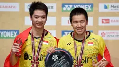 Pasangan ganda putra Indonesia, Kevin Sanjaja Sukamuljo (kiri) dan Marcus Feraidi Gideon berpose dengan trofi juara Japan Open 2017 di Tokyo, Jepang, (24/9). Kevin/Marcus  mengalahkan wakil tuan rumah, Takuto Inoue/Yuki Kaneko. (AFP Photo/Toru Yamanaka)