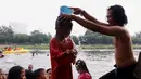 Seorang anak saat dikeramas di bantaran sungai Cisadane di kawasan Babakan, Kota Tangerang, Jumat (1/4/2022). Keramas bersama merupakan tradisi warga yang berada dikawasan tersebur sebagai simbol membersihkan diri untuk menyambut bulan Ramadhan. (Liputan6.com/Angga Yuniar)