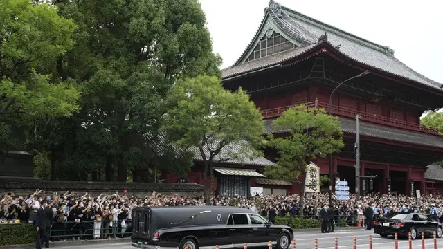Kendaraan yang membawa jenazah mantan Perdana Menteri Jepang Shinzo Abe meninggalkan Kuil Zojoji setelah pemakamannya di Tokyo pada Selasa, 12 Juli 2022. (Foto AP/Hiro Komae)