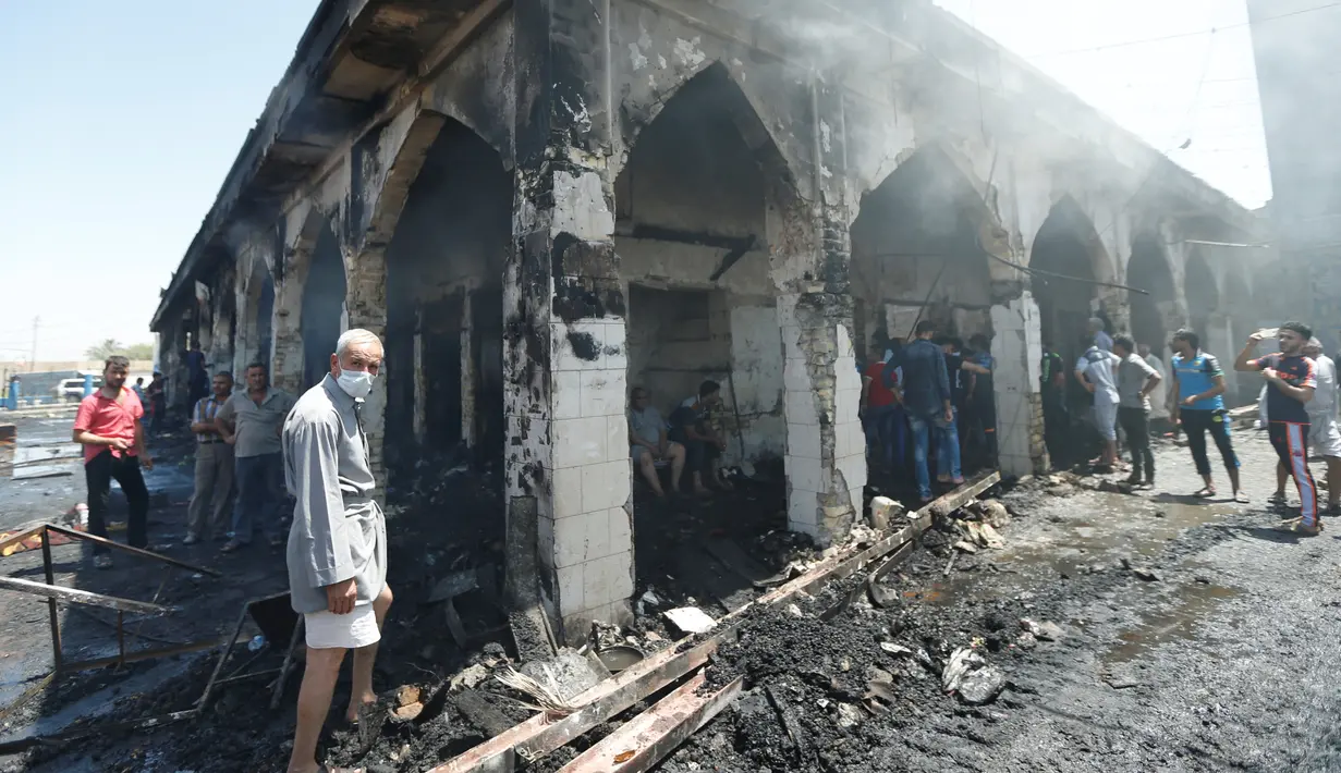 Orang-orang berkumpul melihat kondisi masjid yang terdapat makam Sayid Muhammad bin Ali al-Hadi di Balad usai terkena serangan bom bunuh diri, Baghdad, Irak (8/7). Dikabarkan 30 orang tewas dalam peristiwa tersebut. (REUTERS / Thaier Al-Sudani)