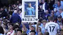 Pendukung Manchester City mengangkat poster bertuliskan "Tak Tergantikan" untuk perpisahan Kevin De Bruyne saat laga pekan ke-37 Liga Inggris 2024/2025 melawan Bournemouth di Etihad Stadium, Manchester, Inggris, Selasa (21/05/2025) waktu setempat. (AP Photo/Dave Thompson)