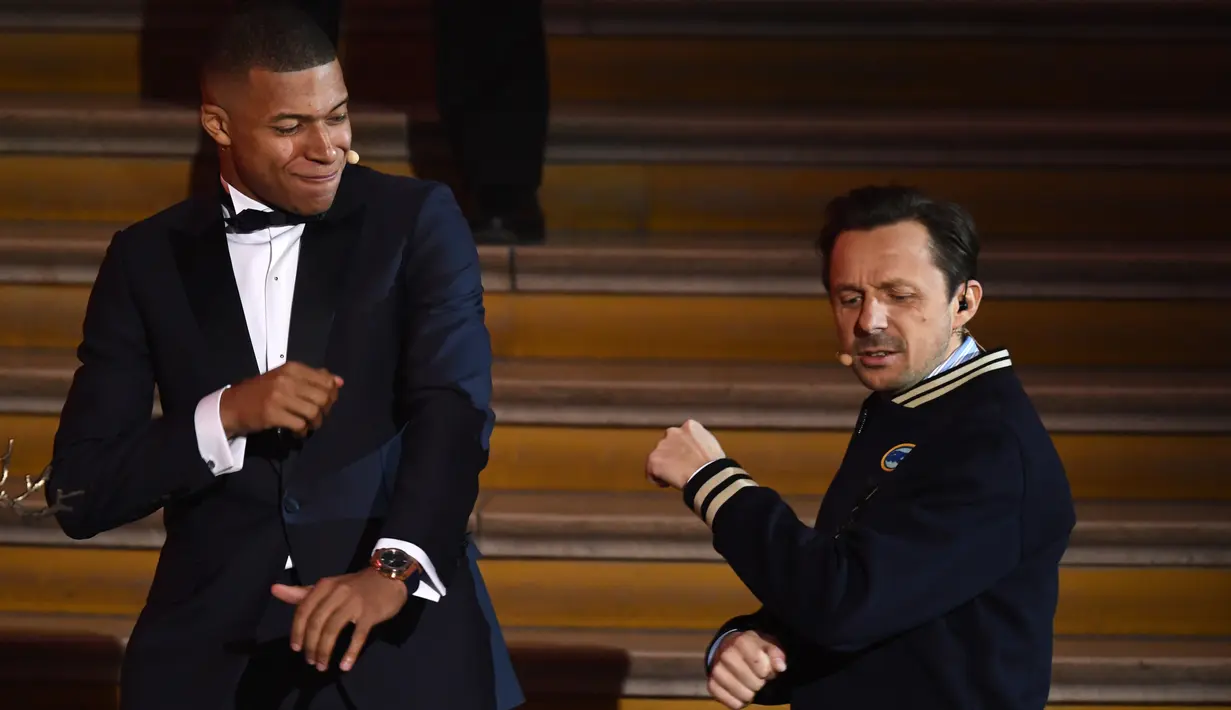 Striker PSG, Kylian Mbappe berjoget bersama DJ Prancis, Martin Solveig Mbappe setelah menerima penghargaan Trophee Kopa pada seremoni Ballon d'Or 2018 di Grand Palais, Senin (3/12). (FRANCK FIFE/AFP)
