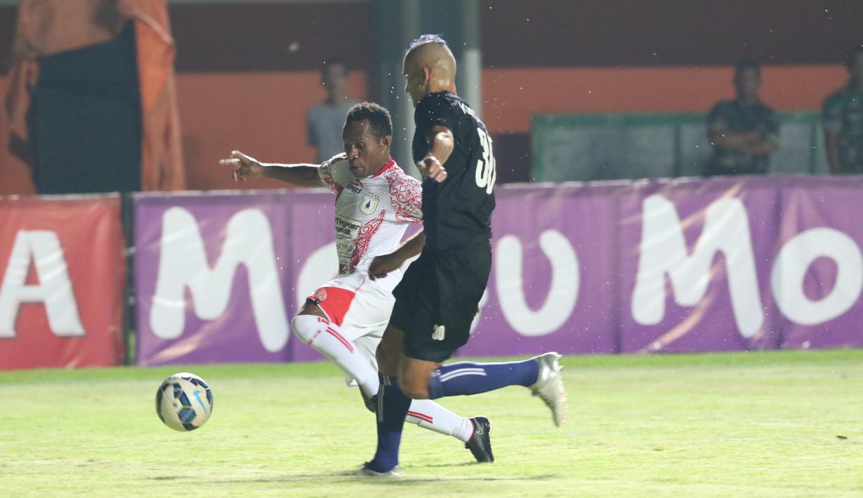 Pemain Persipura Jayapura, Ferinando Pahabol (kiri) berebut bola dengan pemain Arema Cronus Kiko pada laga grup E Piala Jenderal Sudirman di Stadion Maguwoharjo, Sleman, Minggu (13/12/2015) (Bola.com/Nicklas Hanoatubun) 