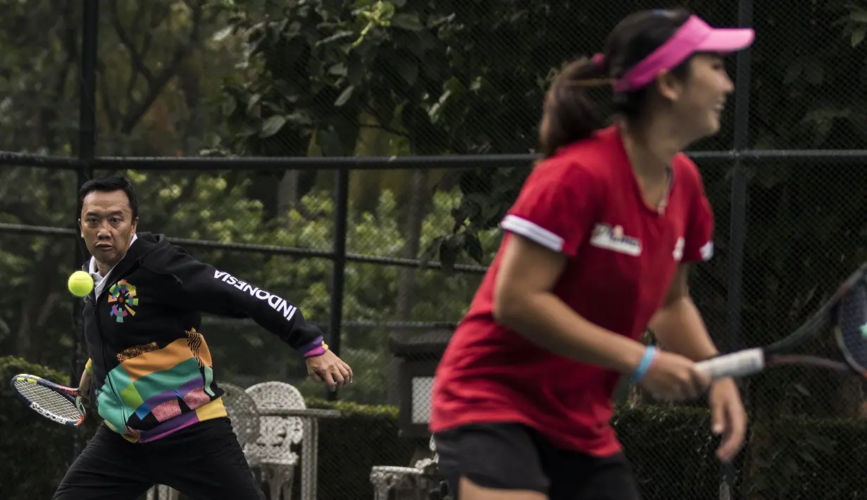 Menpora Imam Nahrawi berusaha memukul bola saat bermain dengan atlet tenis Indonesia di Hotel Sultan, Jakarta, Kamis (24/5/2018). Menpora datang memantau persiapan pelatnas tenis jelang Asian Games 2018. (Bola.com/Vitalis Yogi Trisna)