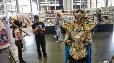 Cosplay mengenakan kostum saint saiya membaca komik selama Comic Con Colombia 2018 di Medellin (16/11). Comic Con Colombia menyatukan penggemar dan pengusaha dari industri hiburan dan permainan berlangsung 16-18 November. (AFP Photo/Joaquin Sarmiento)