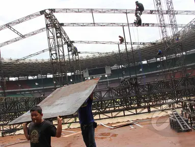 Pekerja membongkar penutup rumput (grass cover) usai konser One Direction di Stadion Utama Gelora Bung Karno (SUGBK), Jakarta, Kamis (26/3/2015). Lapangan SUGBK akan dipersiapkan untuk Pra-Piala Asia U-23. (Liputan6.com/Helmi Afandi)