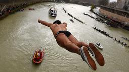 Valter Schirra dari Italia melakukan terjun bebas ke sungai Tiber dari Jembatan Cavour di Roma, Selasa (1/1). Tradisi melompat dari jembatan setinggi 18 meter  dan menyelam ke sungai tersebut sebagai bentuk perayaan tahun baru. (Alberto PIZZOLI/AFP)
