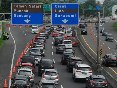 Kendaraan roda empat diarahkan menuju gerbang tol Ciawi saat penutupan jalur menuju Puncak di kawasan Gadog, Kabupaten Bogor, Jawa Barat, Kamis (11/4/2024). (merdeka.com/Arie Basuki)