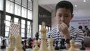 Seorang pecatur cilik tampak serius saat mengikuti kejuaraan catur daerah tingkat provinsi DKI Jakarta di Wisma Catur KONI Jakarta, Minggu (9/7/2017). Kejuaraan ini diikuti oleh 140 anak. (Bola.com/M Iqbal Ichsan)