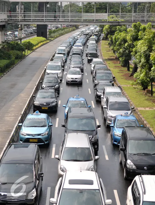 Kendaraan mengular di Jalan Jenderal Sudirman usai hujan reda, Jakarta, Selasa (30/8). Sejumlah ruas jalan utama di Jakarta mulai macet dan menyisakan sendimen tanah di jalan akibat terbawa hujan. (Liputan6.com/Yoppy Renato)