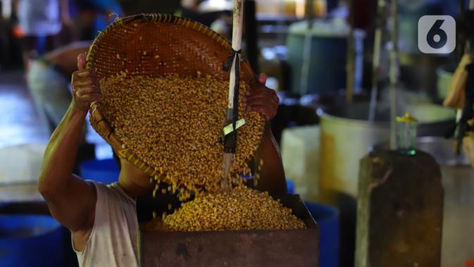 Pekerja menuang kedelai rebus saat proses pembuatan tahu di Jakarta, Senin (4/1/2021). Setelah melakukan mogok produksi selama 1 hingga 3 Januari 2021 akibat naiknya harga kacang kedelei impor, kini para perajin tahu mulai kembali beroperasi. (Liputan6.com/Angga Yuniar)