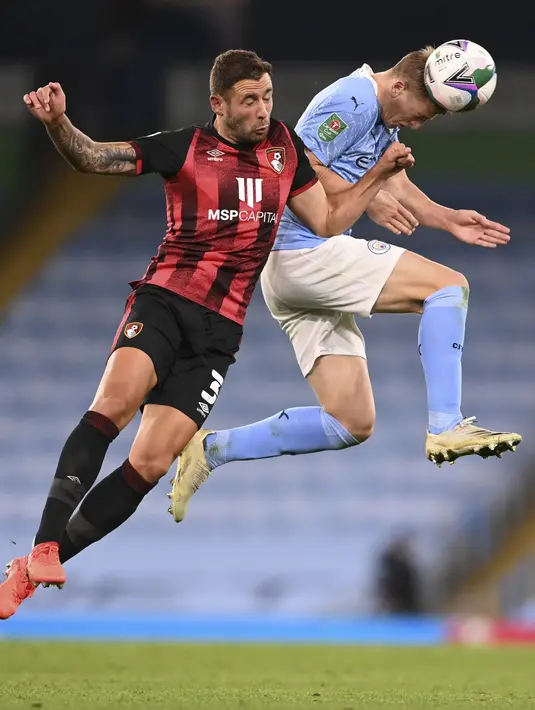 Penyerang Manchester City, Liam Delap berebut bola udara dengan gelandang Bournemouth, David Brooks pada pertandingan putaran ketiga Piala Liga Inggris di City of Manchester Stadium di Manchester, Inggris, Kamis (24/9/2020). City menang tipis atas Bournemouth 2-1. (Laurence Griffiths/Pool via AP)