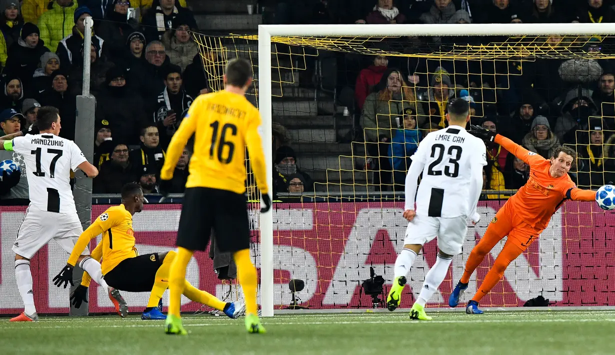 Kiper Young Boys, Marco Woelfli berusaha menahan bola dari pemain Juventus, Mario Mandzukic pada laga pamungkas Grup H Liga Champions di Stade de Suisse, Kamis (13/12). Juventus kalah 1-2 dari tuan rumah, Young Boys. (Anthony Anex/Keystone via AP)