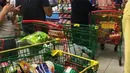 Sejumlah orang mengantre untuk membayar belanjaan mereka di sebuah supermarket di Doha, Senin (5/6). Warga Qatar ramai-ramai membeli bahan makanan dalam jumlah besar menyusul aksi pemutusan hubungan diplomatik dengan lima negara Arab. (@shalome05 via AP)