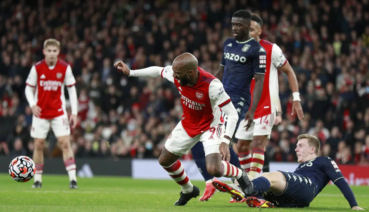 Penyerang Arsenal, Alexandre Lacazette berduel memperebutkan bola dengan pemain Aston Villa, Matt Targett selama pertandingan lanjutan Liga Inggris di i stadion Emirates di London, Sabtu (23/10/2021). Arsenal menang atas Aston Villa dengan skor 3-1. (AP Photo/Ian Walton)
