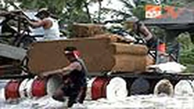 Korban Banjir Angkut Barang dengan Drum