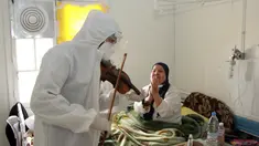 Dr. Mohamed Salah Siala memainkan biola untuk pasien di bangsal COVID-19 rumah sakit Hedi Chaker di Sfax, Tunisia, 20 Februari 2021. Ketika pemain 25 tahun itu memutuskan memainkan biolanya, dia mendapat pujian karena meningkatkan semangat pasien yang terisolasi dan membutuhkan senyuman. (AP Photo)
