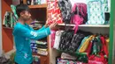Pekerja menata tas dari sampah plastik yang diproduksi di kawasan Pasar Minggu, Jakarta, Senin (13/1/2020). Rumah daur ulang plastik itu memproduksi barang dari limbah plastik seperti tas, payung, dompet dan koper dengan harga jual berkisar Rp20.000 hingga Rp700.000. (Liputan6.com/Immanuel Antonius)
